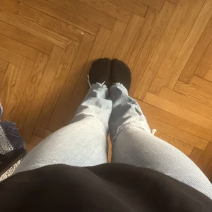 Ljusblå låg midjade bootcut jeans - Snygga ljusblå boot cut jeans från Vero Moda med fransade kanter vid bensluten. De har en klassisk femficksdesign och en röd Vero Moda etikett på bakfickan. Passar mig som är 160cm