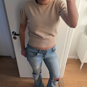 Beige kortärmad tröja - Säljer en tröjan i Kashmir och en ribbad kant. Den ör hyfsat varm. Vet ej vilket märke den ör ifrån för den har inga lappar. 
