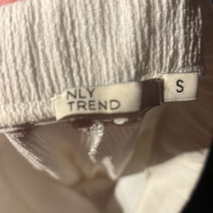 Vita byxor från NLY Trend - Snygga vita byxor från NLY Trend i storlek S. Byxorna har en hög midja och en wide fit som ger en trendig look. Perfekta för en stilren outfit.