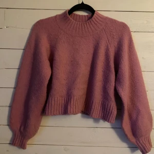 Rosa stickad tröja från Gina Tricot - Säljer en rosa stickad tröja från Gina Tricot. Tröjan har en ribbad krage och muddar.
