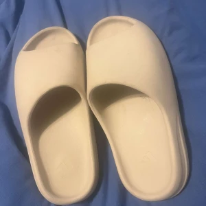 Slides - Säljer ett par stilrena beige slides med enkel design. Perfekta för en avslappnad look.