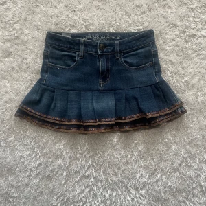 Jeanskjol från American Eagle - En lågmidjad jeanskjol omsydd från ett par jeans. Midjemått tvärsöver - 33cm stretchig  Längd - 29 cm