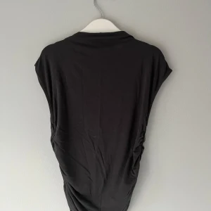 Tight rynkad topp Gina Tricot - Tight rynkad mörkgrå topp från Gina Tricot med korta armar