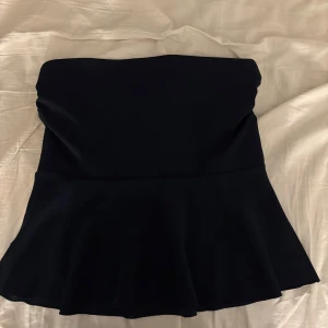 Mörkblå tubtopp från Missay - Snygg mörkblå  tubtopp från Missay med en elegant peplumdetalj som ger en fin siluett. Perfekt för att styla med både jeans och kjol för en chic look. Toppen är axelbandslös och har en stilren design. Endast testad och köpt för 270 kr💞