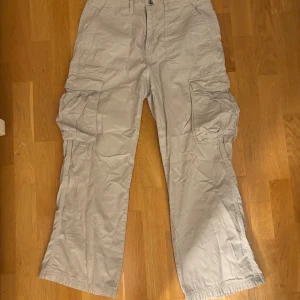 Beige cargobyxor från Bershka - Säljer ett par beige cargobyxor från Bershka. Byxorna har flera praktiska fickor och en straight passform. Perfekta för en avslappnad stil. Storlek EUR 40/USA 8.