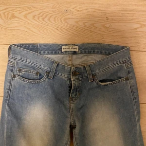 Lågmidjade bootcut jeans från Cross Jeans - Snygga lågmidjade bootcut jeans från Cross Jeans med ljusa slitningar. Säljer pga för små på mig tyvärr. Storlek S/M skulle jag säga men ingen lapp. Midjemått: 85. Innerbenslängd: 75. Säljer fler jeans så kika gärna på min profil💕💕