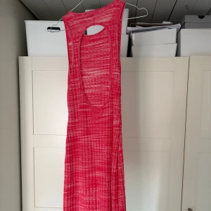 Rosa klänning från Zara - Säljer en snygg rosa ribbad klänning från Zara med ett coolt mönster. Klänningen är ärmlös, har en öppen rygg och är en midiklänning alltså halvlång. Perfekt för en somrig look! 🌸