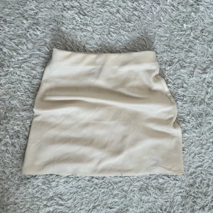 Beige kjol från BikBok - Beige kjol från BikBok i storlek XS. Silkesliknande material