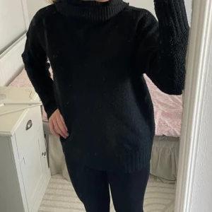 Svart stickad polotröja från 157 - Säljer en svart stickad polotröja från 157. Tröjan har en hög krage och långa ärmar, perfekt för kyligare dagar. Materialet är en blandning av akryl, polyester och elastan vilket ger en mjuk och bekväm känsla. Passar bra till både jeans och kjol.