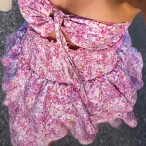 Blommig axelbandslös klänning - Säljer en söt axelbandslös klänning med blommigt mönster i rosa och vit💞