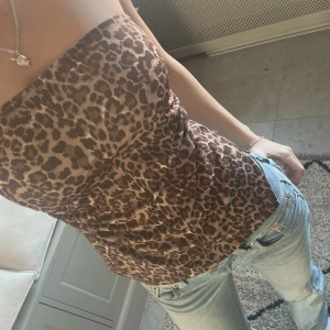 Leopardmönstrad tubtopp - Snygg leopardmönstrad tubtopp i bruna och svarta nyanser. Perfekt för en trendig look, passar bra till jeans eller kjol. Toppen är ärmlös och har en tight passform som framhäver figuren.