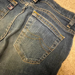 Blå jeans från Crocker - Säljer ett par klassiska blå jeans från Crocker. De har en snygg straight passform och är tillverkade i slitstarkt denim. Jeansen har en traditionell femficksdesign och stängs med dragkedja och knapp. Perfekta för en avslappnad stil.
