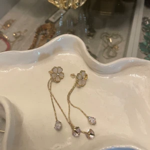 Vita blom örhängen  - Aldrig använda. Ena örhänget saknar ett blomblad. Köpt i en secondhandbutik 