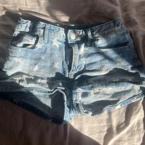 Blå jeansshorts med stjärnmönster från H&M - Blå shorts i storlek 140 