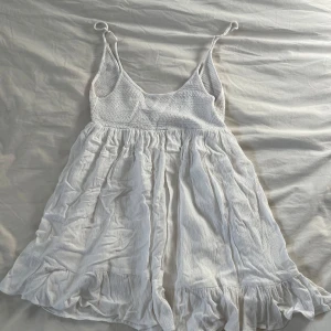 Vit kort sommarklänning - Vit sommarklänning från Pull&Bear. Säljer då den är för liten.