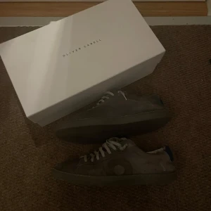 Grå sneakers från Oliver Cabell - Säljer ett par gråa sneakers från Oliver Cabell, modell LOW 1.  Skorna är lite slitna på insidan, men det känns inte när man använder skorna. Hör av dig om du vill köpa!😁 (byten tillåts)