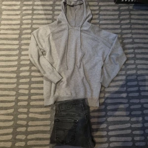 Ljusgrå hoodie - Vann Budgivning.Säljer en enkel och stilren ljusgrå hoodie med huva och dragsnören. Tröjan har långa ärmar och en avslappnad passform, perfekt för en chill vardagslook.