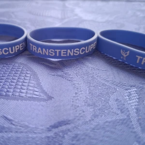 Blått silikonarmband Transtenscupen - Säljer ett blått silikonarmband med vit text 'TRANSTENSCUPEN' och 'I Hallsberg sedan 1990'. Perfekt som accessoar eller minne från cupen.