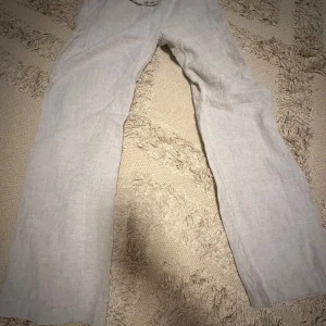 Beiga linnebyxor från A-DSGN - Säljer ett par beiga linnebyxor från A-DSGN i storlek M. Byxorna har rak passform och dragsko i midjan för justerbar passform. Perfekta för varmare dagar tack vare det svala linnematerialet. Går att vika ner kanten om man önskar mef lågmidjat🥰