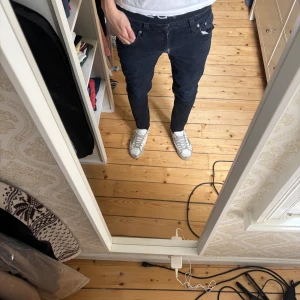 Nudie Jeans - Säljer ett par svarta jeansbyxor från Nudie. Byxorna har en slim passform med klassiska fem fickor och dragkedja. Perfekta för dig som gillar en smal siluett och stilren look. Stolek 32/32