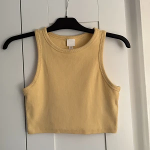 Gul ribbad croppad linnetopp - Gul top från hm, väldigt sparsamt använd. Storlek M. 