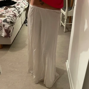 Vit långkjol med resår i midjan - Säljer en enkel och luftig vit långkjol med resår i midjan. Kjolen har en rak och flowy passform som ger en avslappnad känsla. Perfekt för varma dagar eller när du vill ha en stilren look.