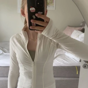 Vit ziptröja från Gina Tricot - Säljer en vit ziptröja från Gina Tricot. Super snygg när man ska träna exempelvis. Säljer då jag bara använt den två gånger 