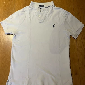 Vit piké från Polo Ralph Lauren - Nu säljer jag min vita pikétröja från Polo Ralph Lauren med broderad logga på bröstet. Slim fit-storlek S med korta ärmar. Den är i mycket bra skick och säljs för endast 200kr. OBS!(det mörka på pikén är min skugga) Jag svarar snabbt med snabb leverans.