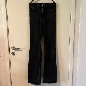 Svarta bootcut jeans - Säljer ett par svarta jeans med bootcut passform. Jeansen har klassisk femficksdesign, hög midja och är tillverkade i ett stretchigt denimtyg. Finns små skavanker men inget som hindrat mig från att använda dem.