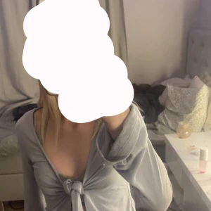 Ljusblå croppad kofta med knyt - Säljer en ljusblå croppad kofta med knyt framtill. Tröjan har långa ärmar och är gjord i ett mjukt material som känns skönt mot huden. Perfekt att slänga på sig över ett linne eller topp.