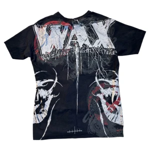 Svart grafisk t-shirt från WAX - Cool svart t-shirt från WAX med stora grafiska tryck i vitt, rött och grått. Framsidan har ett motiv med tigrar och text, samt blixtar och detaljer i streetstil. Perfekt för dig som gillar unika och edgy plagg.
