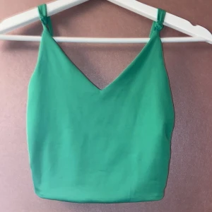 Grön linnetopp med v-ringning - Snygg grön linnetopp med smala axelband och v-ringad