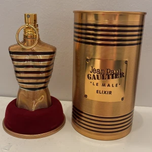 Jean Paul Gaultier elixir  - Exklusiv herrparfym i en ikonisk guld- och svartrandig flaska formad som en manlig torso. Kommer med originalförpackning i metall med matchande design. Doften är intensiv och modern, perfekt för dig som vill sticka ut. Nästan full. Går inte under 400kr