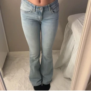 low waist Ljusblå bootcut jeans - Säljer ett par ljusblå jeans med bootcut-modell och låg midja. Jeansen har klassisk femficksdesign, knapp och dragkedja framtill. Perfekta för en avslappnad och trendig look.