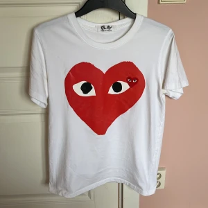 CDG T-shirt  - Vit t-shirt från Comme des Garçons Play med det ikoniska röda hjärtat med ögon tryckt på bröstet. Klassisk passform och stilren. Storleken på tröjan är M men passar mer som S. Nypris runt 1000-1300 mitt pris 550. Skriv vid mer frågor.