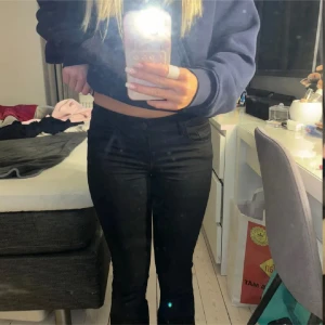 Svarta lågmidjade bootcut-byxor från ONLY - Säljer ett par svarta lågmidjade bootcut-byxor från ONLY. Byxorna har klassisk femficksdesign och är tillverkade i ett stretchigt material som sitter snyggt på kroppen. Perfekta för dig som gillar en tidlös look med lite utsvängda ben. Denna modellen är helt slutsåld, storlek xs/34