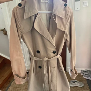 Beige trenchcoat med bälte - Säljer en ljus beige trenchcoat! 
