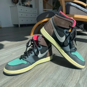 Nike Air Jordan 1 Retro High OG - Säljer ett par Nike Air Jordan 1 Retro High OG med svart, brun och turkos färgkombination. Skorna har klassisk snörning, rund tå och en kontrasterande sula. Perfekta för dig som vill sticka ut med en unik sneaker.