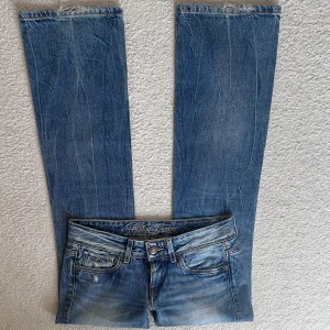 Blå jeans från Hilfiger Denim - Supersnygga lågmidjade jeans från Tommy Hiliger i storlek 27/32 💕💕💕Skulle säga att de är raka/utsvängda i benen💕💕Supersnygga slitningar på ena knät!! Midjemått: 82, Innerbenslängd: 81, Grenhöjd: 20💕💕