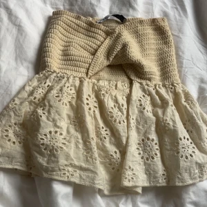 Beige Tubtopp från Zara  - Supersöt beige tubtopp med virkad, stretchig material och broderade blommor. Priset kan diskuteras vid snabbt köp. 