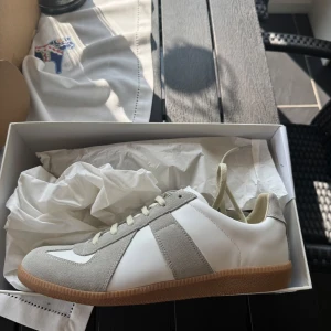Maison Margiela Gats (äkta) - Maison Margiela Gats. Helt nya och oanvända, ligger fortfarande kvar i skoboxen. Säljes på grund av att sidan jag beställde från inte tog emot returer om det inte var fel på varan. Äkta och legit checkade via sidan jag beställde ifrån, kvitto och orderbekräftelse kan fås. Dustbag och skobox ingår. Hör av er vid frågor!