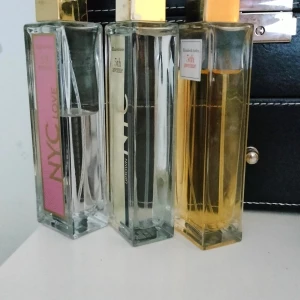 Parfymtrio från Elizabeth Arden NYC & 5th Avenue - Tre eleganta parfymer från Elizabeth Arden: NYC Love med rosa etikett, NYC Uptown med guldig etikett och 5th Avenue med vit etikett och bärnstensfärgad vätska. Alla flaskor är rektangulära med guldfärgade lock och transparent glas. En av dom är nästan full, på bilderna ser ni hur mycket det är kvar i varje.  Säljer alla tre tillsammans. 