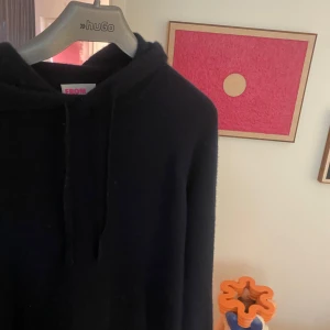 Mörkblå hoodie i kashmir från From Future - Mysig mörkblå hoodie från From Future i mjuk kashmir. Klassisk modell med huva och snörning, samt långa ärmar. Perfekt för dig som gillar stilrena och bekväma plagg med premiumkänsla. Lite nopprig men inga som helst defekter