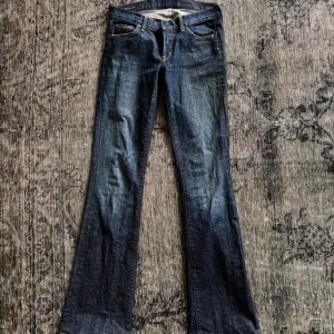 Mörkblå bootcut jeans från 7 For All Mankind - Snygga mörkblå bootcut jeans från 7 For All Mankind by Jerome Dahan. Klassisk femficksmodell med kontrastsömmar och broderade bakfickor. Jeansen är i stretchig denim och har låg midja för en avslappnad vibe.