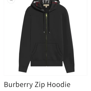 Svart hoodie med dragkedja från Burberry - Svart hoodie från Burberry med hel dragkedja och klassisk huva. Insidan av huvan har Burberrys ikoniska rutiga mönster. Tröjan har fickor framtill och snörning i huvan. Perfekt för en chill och stilren look.