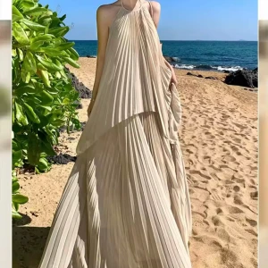 Set maxi 2 delar långklänning med halterneck plisserad - Säljer en elegant, ljusbeige plisserad långklänning med halterneck och öppen rygg. Klänningen har ett luftigt fall och knytning i nacken, perfekt för varma dagar vid stranden. Materialet är lätt och ger en lyxig känsla.                    Stl M men passar S 
