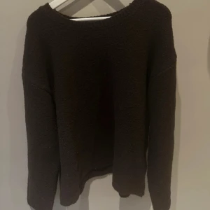 Mörkbrun stickad tröja från BikBok - Mysig mörkbrun stickad tröja från BikBok med rund halsringning och långa ärmar. Perfekt för kyligare dagar och enkel att matcha med olika outfits.