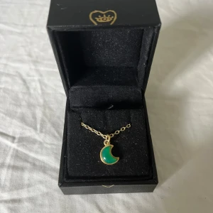 Maria Nilsdotter halsband  - Superfint halsband från Maria Nilsdotter i guld med en grön måne, både kedja och box ingår. Sparsamt använd, säljes för 2000 men priset kan diskuteras vid en snabb affär