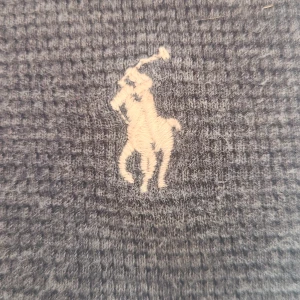 Grå v-ringad tröja från Polo Ralph Lauren - Säljer en grå v-ringad tröja från Polo Ralph Lauren i 100% bomull. Tröjan har lång ärm, vit broderad logga på bröstet och ribbade muddar. Perfekt för dig som gillar klassisk och stilren design. Nypris ligger runt 1800 kr, men mitt pris är såklart inte hugget i sten!🤩 Hör gärna av er vid frågor!😁