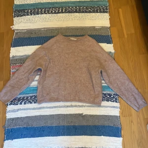 Ljusrosa stickad tröja - Mysig ljusrosa stickad tröja med lång ärm och enkel, rak passform. Perfekt för lager-på-lager och passar till både jeans och kjol. Tröjan har en klassisk rund halsringning och är superenkel att styla.